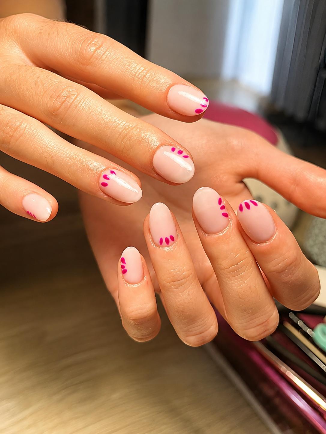 Manicura nude con detalle de pétalos fucsia